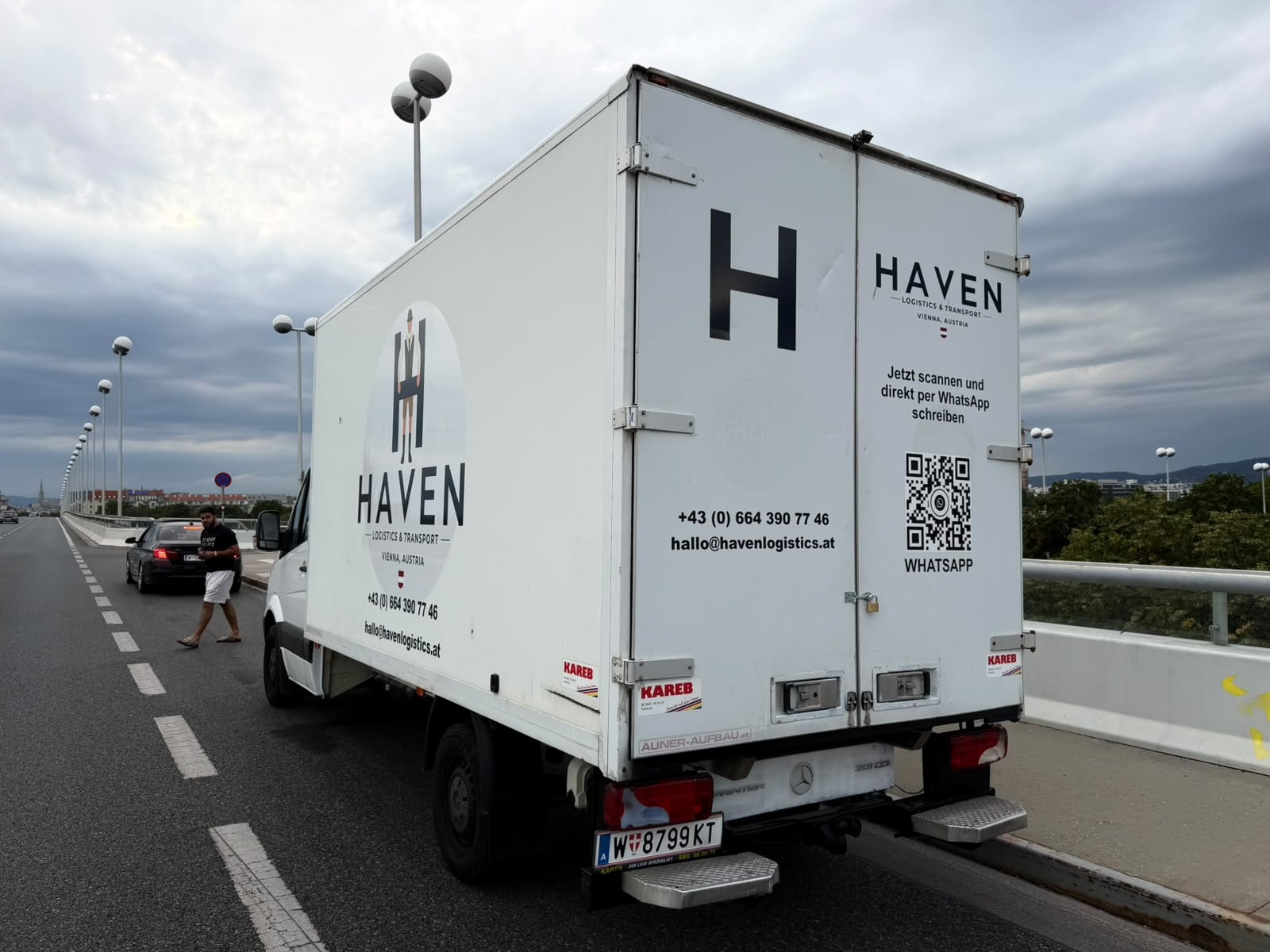 Heckansicht des HAVEN-Sprinters mit Koffer-Aufbau, Telefonnummer und QR-Code für WhatsApp